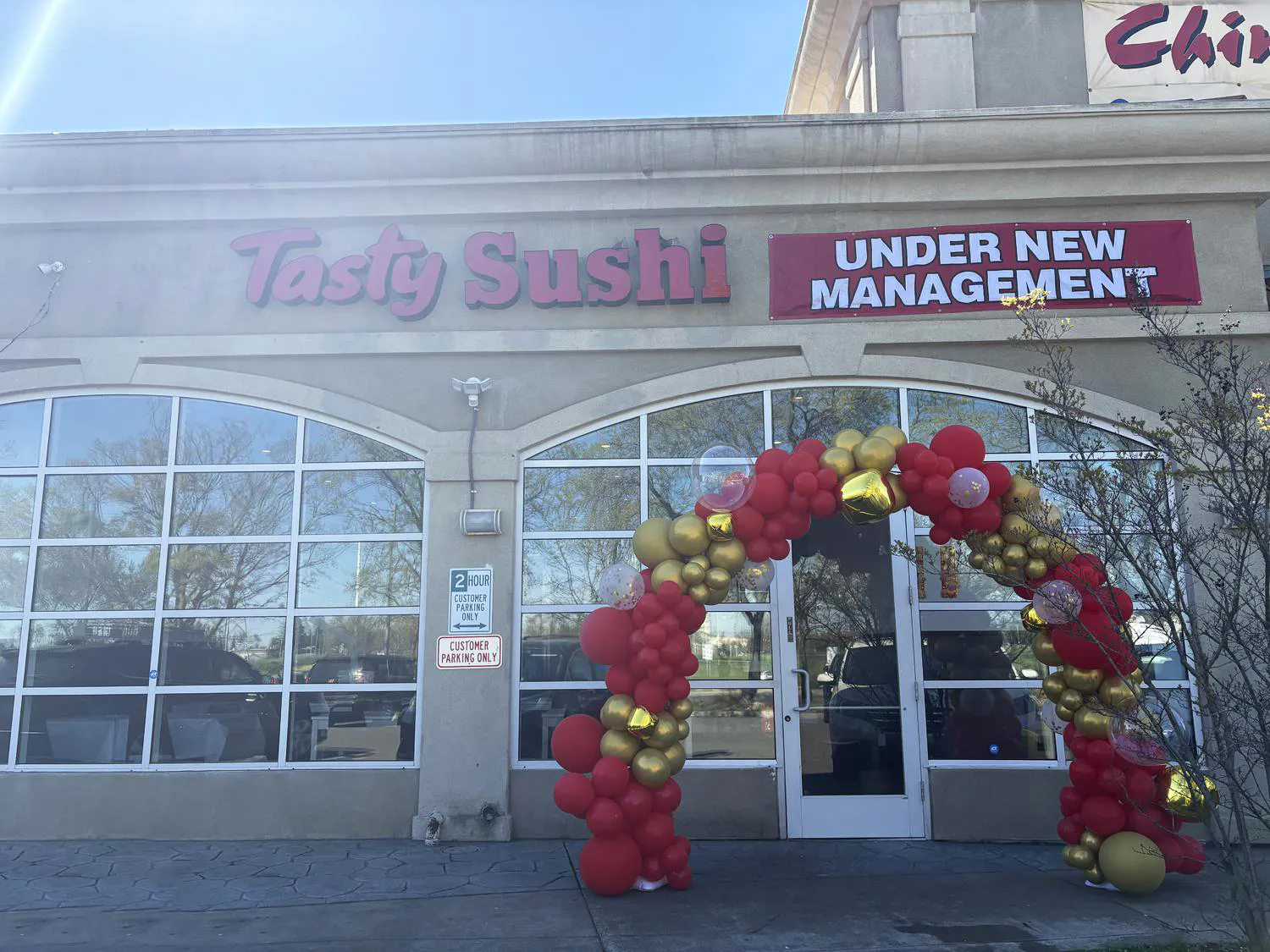 storefront with red and gold balloon arch at Tasty Sushi, a Japanese Restaurant in Sacramento